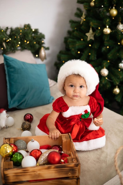 Wesołych Świąt Portret uroczej rocznej dziewczynki w przytulnej sypialni ubranej na świąteczny styl życia
