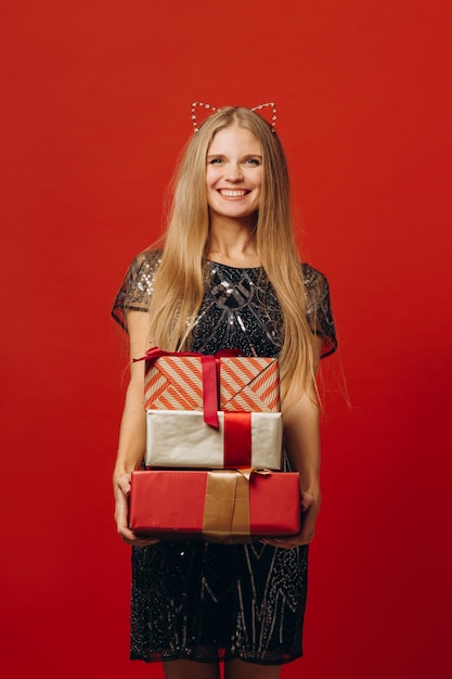 Wesołych Świąt szczęśliwa blondynka w świątecznej sukience trzymająca portret prezentów świątecznych stock photoxA