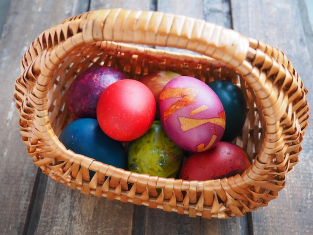 Wesołych Świąt Wielkanocne kolorowe jajka w wiklinowym koszu na drewnianym stole Wielkanoc Zmartwychwstanie Chrystusa Jasne Zmartwychwstanie Chrystusa najstarsze i chrześcijańskie święto