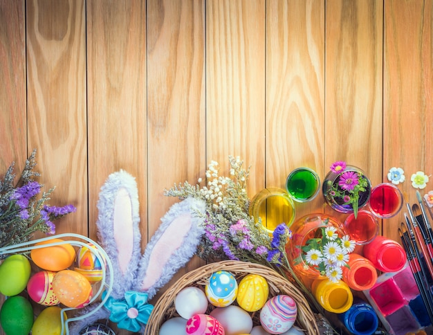Wesołych świąt wielkanocnych kolorowe jajka i kwiat zestaw farb do żywności, akrylowy pędzel do zrób to sam na brązowej drewnianej podłodze z miejsca kopiowania