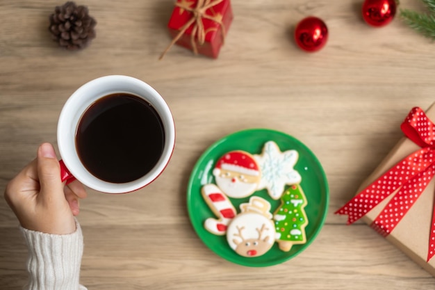 Wesołych Świąt z kobietą ręką trzymającą filiżankę kawy i domowe ciasteczka na stole Święta wigilijne wakacje i szczęśliwego nowego roku koncepcja