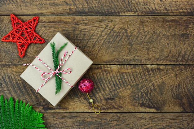 Wesołych świątecznych dekoracji. Pudełko prezentowe i jodła na drewnianej desce, leżące na płasko przedmioty różnicowe