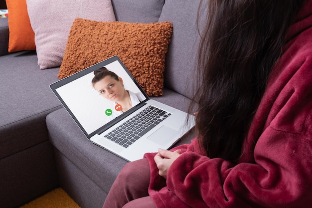 Wezwanie lekarza do leczenia online za pomocą telemedycyny Kobieta konsultuje się z lekarzem online za pomocą laptopa