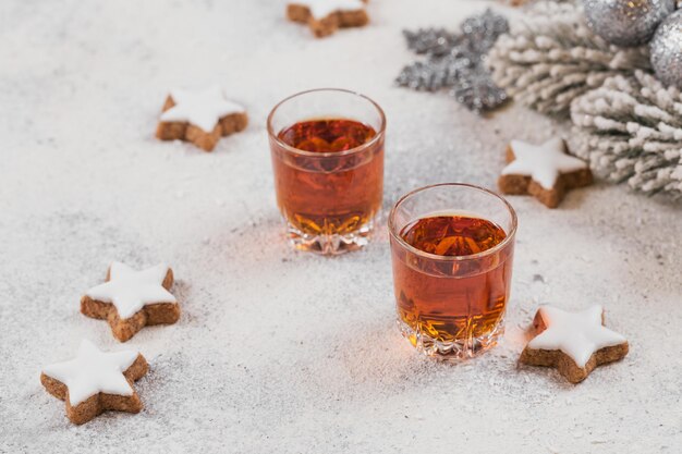 Whisky, brandy lub likier, ciasteczka i dekoracje chrastmas na białym tle. Koncepcja ferii zimowych.