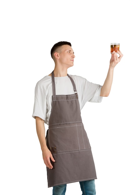 Whisky Portret młodego męskiego baristy rasy kaukaskiej lub barmana w brązowym fartuchu uśmiechnięty