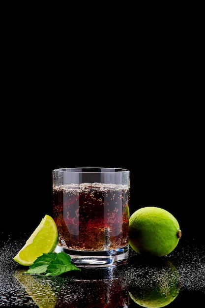 Whisky ze stalowymi kostkami chłodzącymi na szkle na ciemnej powierzchni