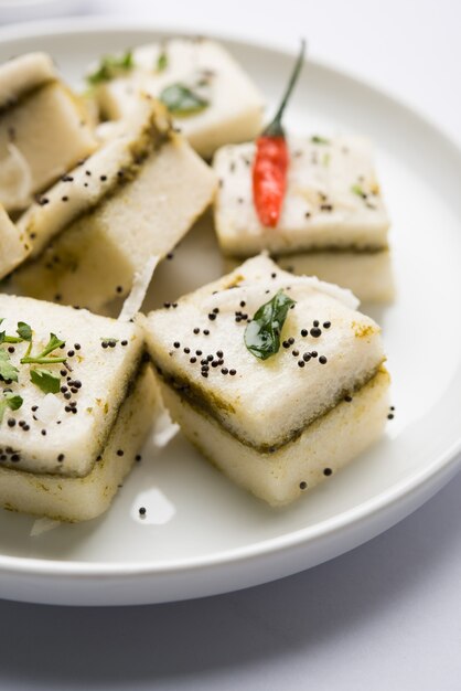 White Sandwich Dhokla to indyjska pikantna przekąska z mąki z ciecierzycy lub mąki ryżowej, pochodząca z Gudżaratu. Podawany z chutneyem z zielonego i tamaryndowca. selektywne skupienie