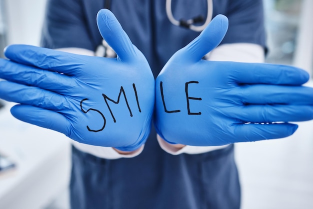 Zdjęcie wiadomość o opiece zdrowotnej i ręce lekarza z rękawiczkami dla uśmiechu, bezpieczeństwo medyczne i informacje, pokazującą operację i pielęgniarkę lub chirurga ze słowami motywującymi zdrowie i wsparcie w klinice