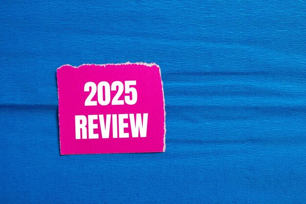 Wiadomość o przeglądzie 2025 napisana na rozdarty różowy kawałek papieru z niebieskim tłem Konceptualny symbol przeglądu 2025 Kopiuj przestrzeń