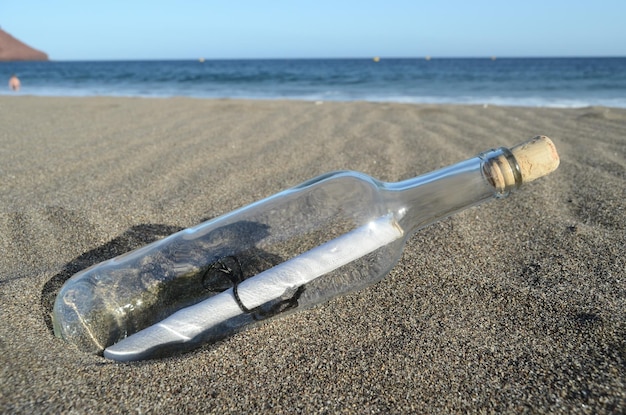 Zdjęcie wiadomość w butelce na piaszczystej plaży