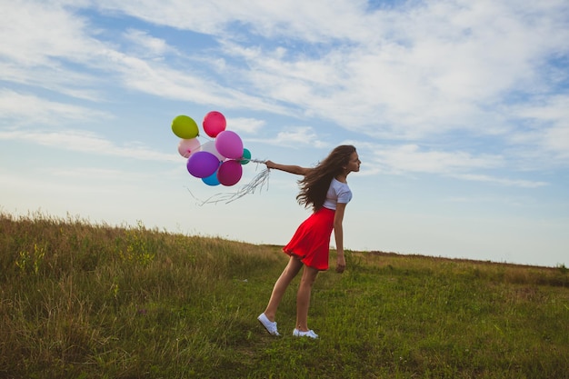 Wiatr rozwiewa balony w dłoni młodej dziewczyny