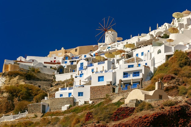 Wiatraki i białe domy w Oia lub Ia na wyspie Santorini, Grecja