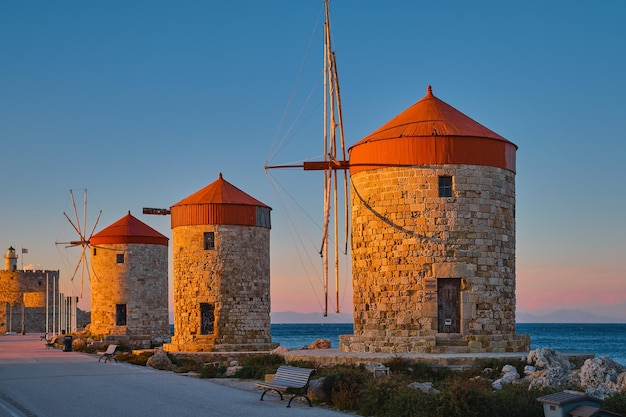Wiatraki na brzegu zatoki podczas zachodu słońca w mieście Rodos na wyspie Rodos na wyspie archipelagu Dodekanezu EuropaWakacje i popularny cel podróży