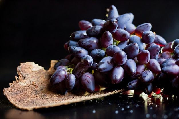 Wiązka dojrzali ciemnoniebiescy winogrona na ciemnym tle