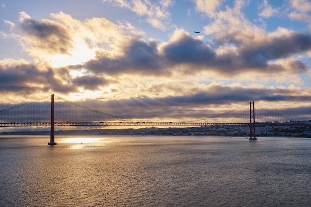 Widok 25 de Abril Most nad rzeką Tag na zachodzie słońca Lizbona Portugalia