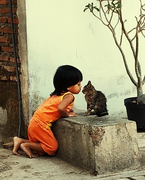 Zdjęcie widok boczny chłopca całującego kota na zewnątrz