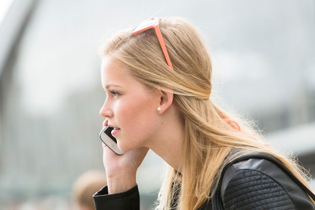 Zdjęcie widok boczny kobiety rozmawiającej przez smartfon