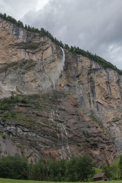 Zdjęcie widok closeup wodospad staubbach wchodzą w góry, dolina wodospadów w parku narodowym lauterbrunnen, szwajcaria, europa. letni krajobraz, słoneczna pogoda, dramatyczne błękitne niebo i słoneczny dzień