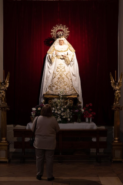 Widok kobiety modlącej się do Dziewicy w kościele w Alcal de Henares w Madrycie