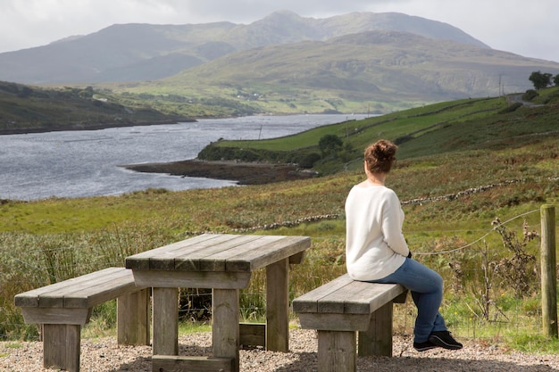 Widok młodej kobiety patrzącej na jezioro Killary Fjord w Leenane Connemara w Irlandii