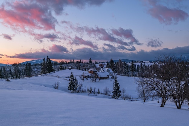 Widok na alpejskie szczyty zimowego zachodu słońca z górskiej wioski Malownicza sezonowa natura i scena koncepcyjna piękna wsi