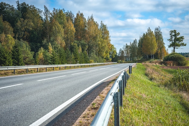 Widok Na Autostradę Jesienią. Tło Podróży. Autostrada Asfaltowa Przebiegająca Przez Las. łotwa. Bałtycki.