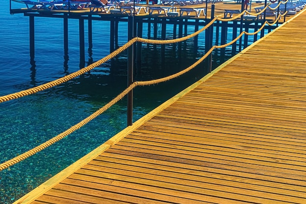 Widok na drewnianą podłogę molo i błękitne morze w Turcji Kemer