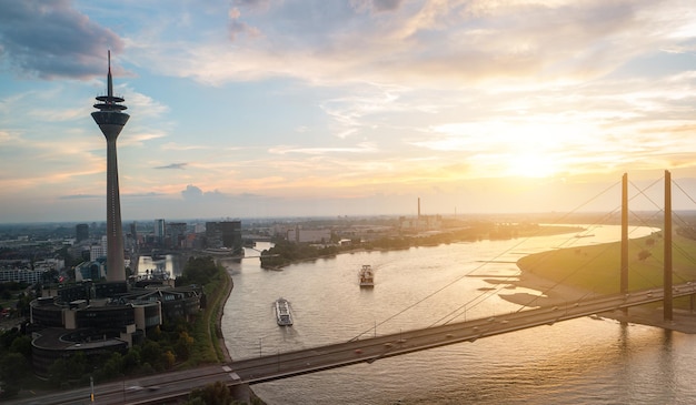 widok na Dusseldorf o zachodzie słońca z wieżą renu (Rheinturm) i mostem nad renem. idealny do układów stron internetowych i czasopism