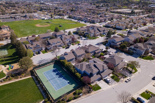 Widok na dzielnicę mieszkaniową z kortem tenisowym na ziemi.