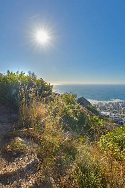Widok na horyzont nad oceanem i pod czystym, błękitnym niebem ze słońcem i kopią przestrzeni Krajobraz morski ze szczytu góry Lions Head w Cape Town w RPA