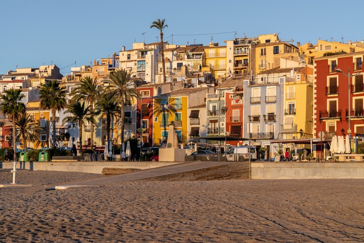 Widok na kolorowe domy miasta Villajoyosa z plaży o wschodzie słońca, Alicante, Hiszpania.