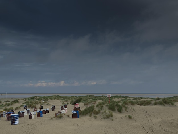 Zdjęcie widok na krzesła z kapturem na plaży na chmurnym niebie