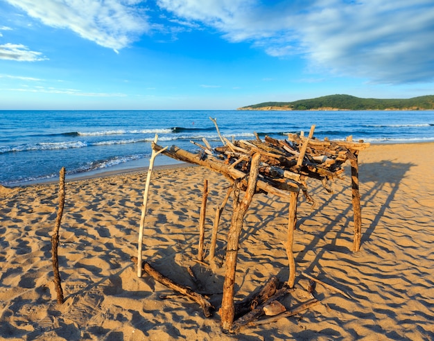 Zdjęcie widok na letnie wybrzeże (bułgaria) z piaszczystą plażą i małą drewnianą markizą przed słońcem.