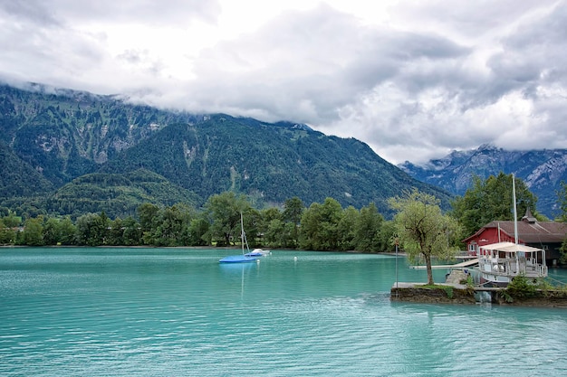 Widok na łodzie w pobliżu brzegów jeziora Brienz przy pochmurnej pogodzie