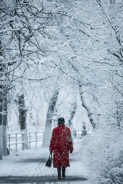 Widok na miasto, śnieżna pogoda, zimowe ulice miasta, mężczyzna w czerwieni