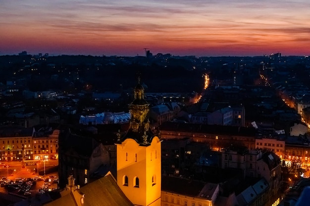 Widok na oświetloną katedrę łacińską i zabytkowe centrum Lwowa o zachodzie słońca. Widok na panoramę Lwowa z ratusza