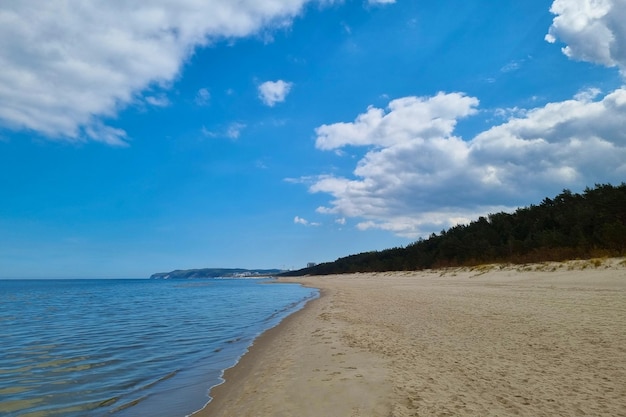 Widok na piaszczyste wybrzeże Bałtyku Rozpryski wody Słoneczny dzień na plaży Pejzaż morski Zmiana klimatu natury