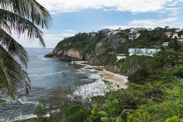 Widok na plażę Joatinga, Rio de Janeiro, Brazylia. Dzień z niebieskim niebem i chmurami.