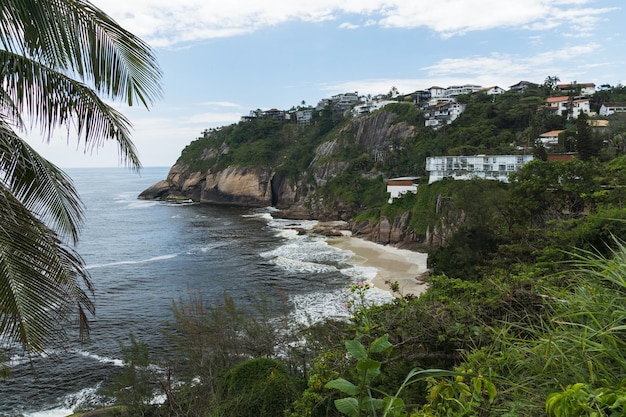 Widok na plażę Joatinga, Rio de Janeiro, Brazylia. Dzień z niebieskim niebem i chmurami.