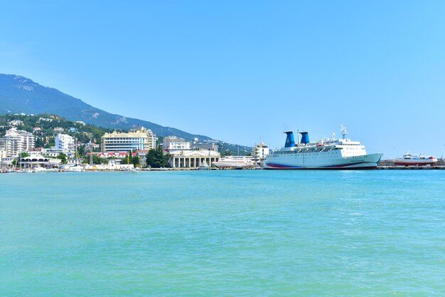 Widok na port morski ze statkami i budynkami Spokojne błękitne morze i góry Yalta Crimea