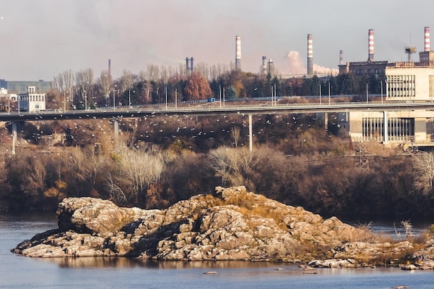 Widok na przemysłowe miasto Zaporoże na Ukrainie. Emisje smogu z kominów fabryk metalurgicznych. Problem zanieczyszczenia środowiska i globalnego ocieplenia