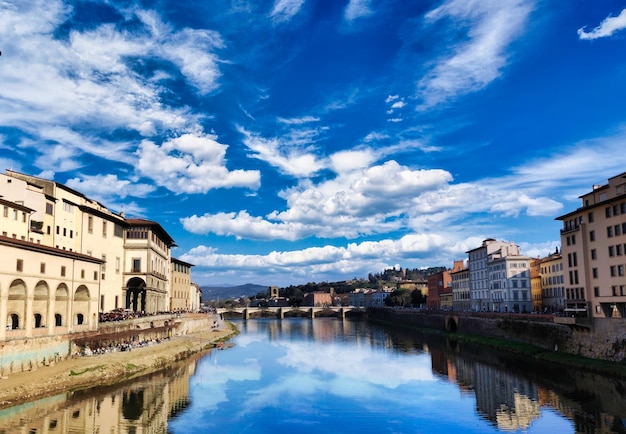 Widok na rzekę Arno we Florencji w słoneczny i pochmurny dzień wiosny