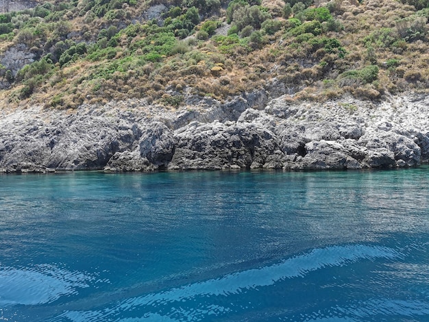 Widok na skaliste wybrzeże błękitnego Morza Egejskiego z wody Turcja Kusadasi