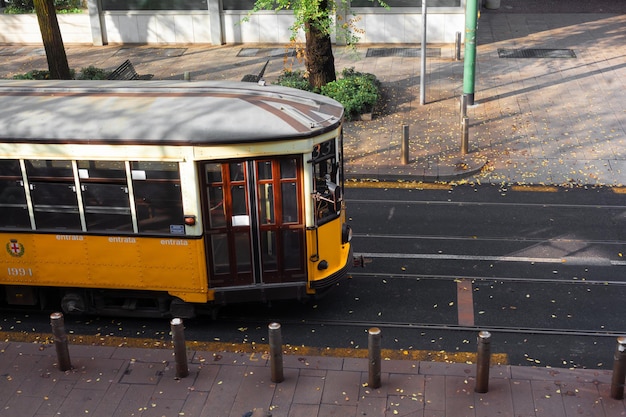 Zdjęcie widok na stary zabytkowy tramwaj pomarańczowy na ulicy mediolan, włochy