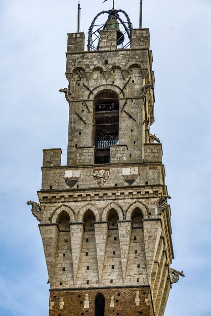 Widok na szczyt wieży Torre del Mangia w Sienie, Włochy