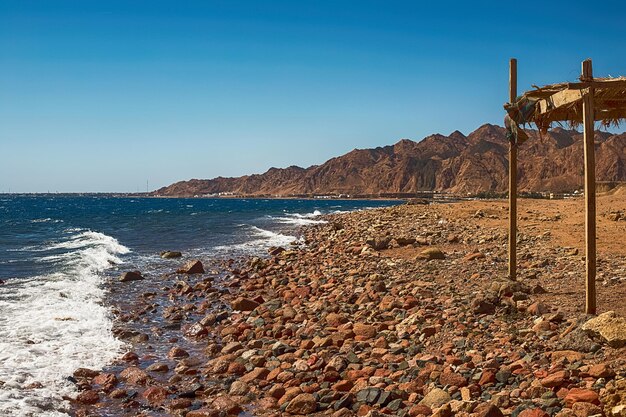 Zdjęcie widok na wybrzeże morza czerwonego, kamionkowa plaża i kami z bliska, koncentracja wypoczynku, egipt, dahab