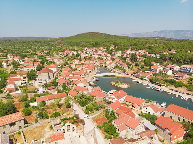 Widok na zatokę i stare miasto z twierdzą i kościołem w miejscowości Vrboska na wyspie Hvar w Chorwacji