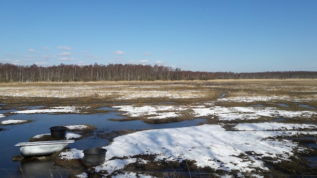 Widok natura z śniegiem i jeziorem w polu w wiosna czasie