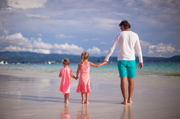 Widok ojca i dwie dziewczyny na tropikalnej białej plaży z tyłu