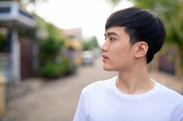Widok profilu młodego człowieka azjatyckiego myślenia na ulicy